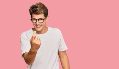 Yakışıklı, beyaz, günlük kıyafetler ve gözlük takan bir adam seni buraya davet ediyor. Elinle hoş geldin diyor ve gülümsüyor. 