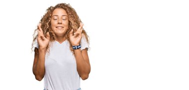 Beyaz tişört giyen güzel beyaz kız umut ve gözlerin kapalı bir şekilde gülümseyerek bana işaret ediyor. Şans ve batıl inançlar. 