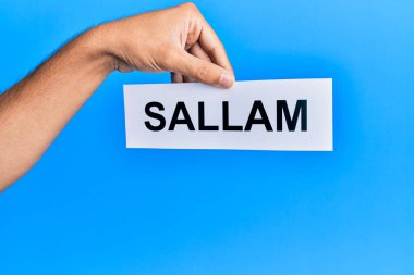 El sallam kelime kağıdını mavi arka planda tutan İspanyol bir adam..