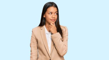 Güzel İspanyol kadın, eli çenesinde iş ceketi giyiyor. Soru sormayı düşünüyor. Düşünceli bir ifade. Düşünceli bir yüzle gülümsüyor. şüphe kavramı. 