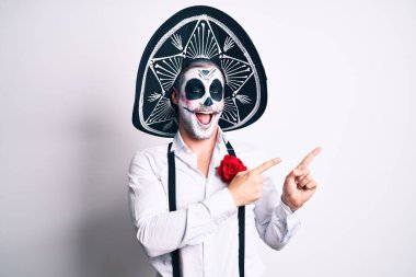 Ölü kostümün giyildiği gün beyazların üzerine gülümseyen ve kameraya bakan adam iki elini ve parmaklarını kenarı işaret ediyor.. 