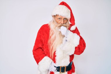 Gri saçlı ve uzun sakallı yaşlı bir adam Noel Baba kostümü giyiyor. Pantolon askısı takıyor ve kendini kötü hissediyor. Soğuk algınlığı veya bronşitin belirtisi olarak öksürüyor. sağlık hizmeti kavramı. 