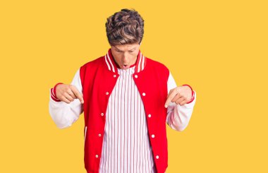 Beyzbol üniforması giyen genç yakışıklı adam parmaklarını göstererek reklamını yapıyor, şaşırmış bir yüz ve açık bir ağız. 