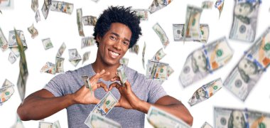 Yakışıklı Afro saçlı, sıradan kıyafetler giyen, aşık bir şekilde gülümseyen, elleriyle kalp sembolü yapan Afro-Amerikan bir adam. romantik kavram.