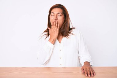 Orta yaşlı esmer, İspanyol iş kadını, gündelik beyaz gömleğini giymiş masada oturmuş, esnemekten sıkılmış, ağzı eliyle kapatmaktan bıkmış. Huzursuz ve uykulu.. 