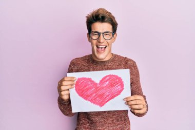 Kalbi olan yakışıklı beyaz adam çılgınca kutlama yapıyor ve şaşırıyor. Gözleri açık bağırıyor. Heyecanlı.. 