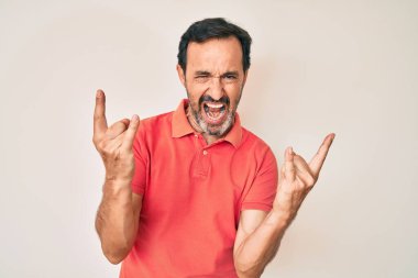 Orta yaşlı İspanyol bir adam gündelik kıyafetler giyip çılgın bir ifadeyle bağırıyor ve elleri havada rock sembolü yapıyor. Müzik yıldızı. ağır kavram. 