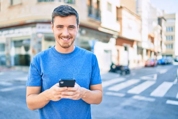 Joven Hombre Caucásico Sonriendo Feliz Usando Teléfono Inteligente Ciudad —  Fotos de Stock