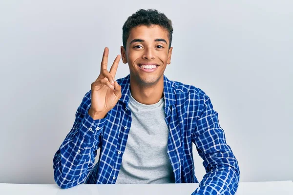 Jovem Afro Americano Bonito Vestindo Roupas Casuais Sentado Mesa Sorrindo — Fotografia de Stock