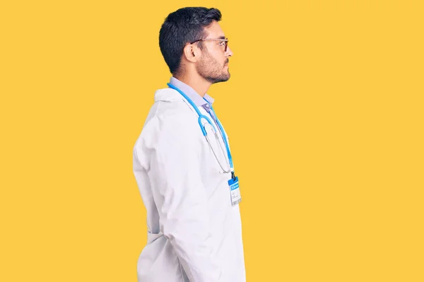 Junger Hispanischer Mann Arztuniform Und Stethoskop Mit Seitlichem Blick Entspannter — Stockfoto