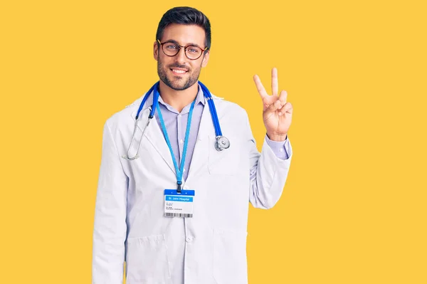 Pemuda Hispanik Yang Mengenakan Seragam Dokter Dan Stetoskop Tersenyum Melihat — Stok Foto