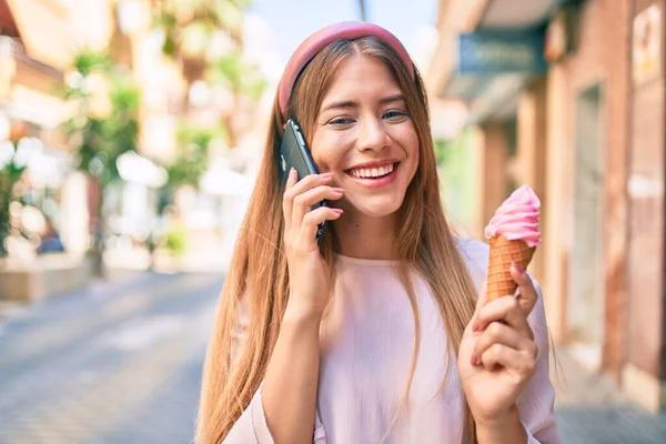若いです白人の女の子はスマートフォンで話して街でアイスクリームを食べます — ストック写真