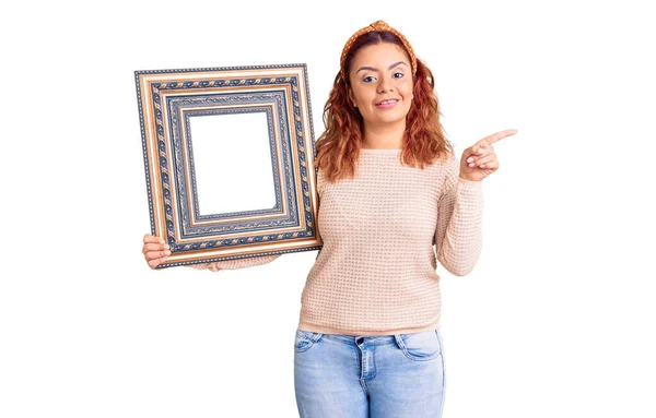 Jong Latijn Vrouw Houden Leeg Frame Glimlachen Gelukkig Wijzend Met — Stockfoto