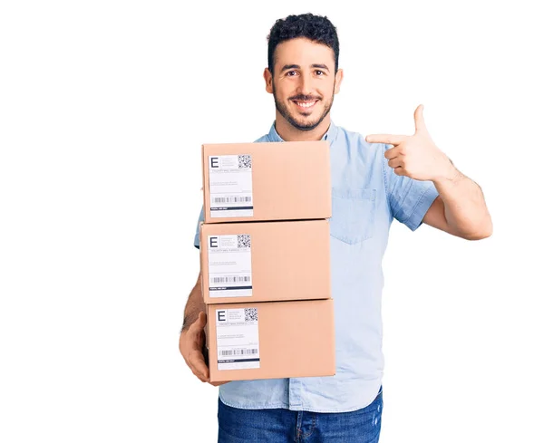 Jonge Spaanse Man Houdt Levering Pakket Glimlachend Gelukkig Wijzend Met — Stockfoto