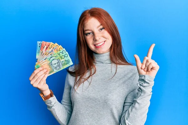 Joven Cabeza Roja Chica Sosteniendo Dólares Australianos Sonriendo Feliz Señalando — Foto de Stock