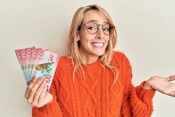 Beautiful Blonde Woman Holding 100 New Zealand Dollars Banknote Celebrating — Stock Photo, Image