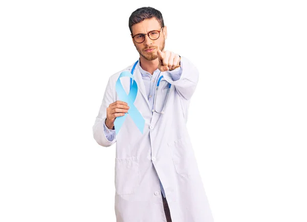 Guapo Joven Con Oso Vistiendo Uniforme Médico Sosteniendo Cinta Azul —  Fotos de Stock