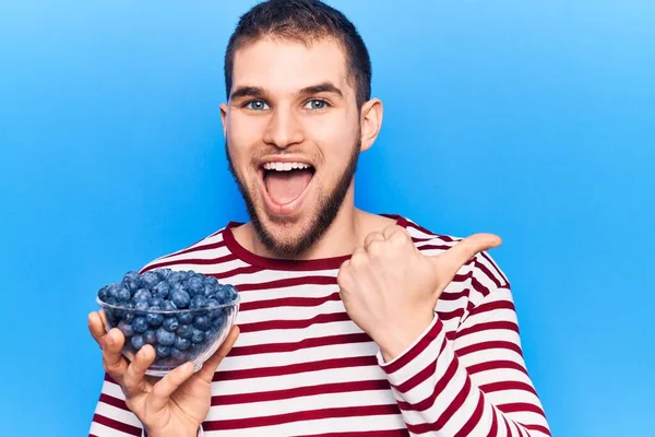 Jeune Homme Beau Tenant Bol Avec Des Bleuets Pointant Pouce — Photo