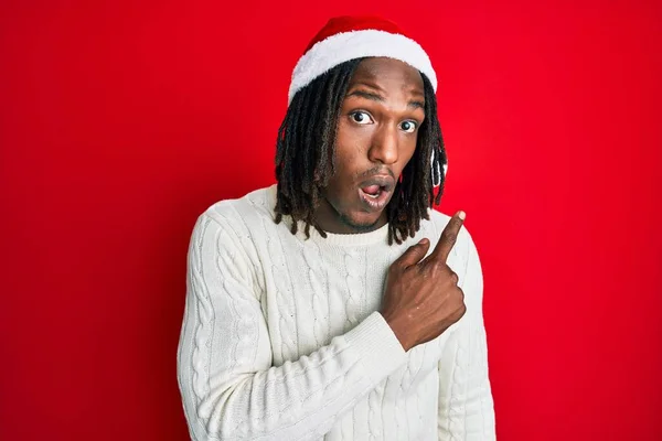 Africano Americano Com Tranças Vestindo Chapéu Natal Surpreso Apontando Com — Fotografia de Stock