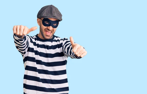 Homem Bonito Jovem Vestindo Máscara Ladrão Aprovando Fazer Gesto Positivo — Fotografia de Stock
