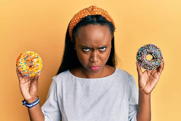 Jonge Afrikaanse Vrouw Met Smakelijke Kleurrijke Donuts Sceptisch Nerveus Fronsend — Stockfoto