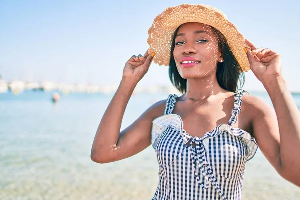 Young african american woman on vacation smiling happy walking at the beach