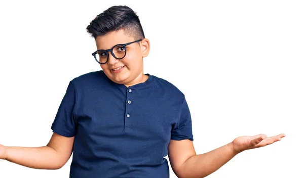 カジュアルな服と眼鏡を身に着けている小さな男の子は 腕や手を上げて混乱した表情 疑わしい概念 — ストック写真