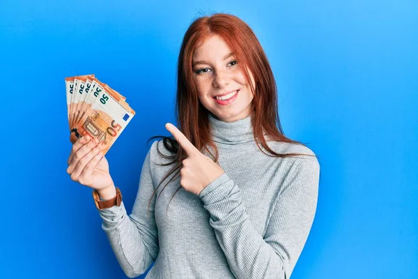 Joven Chica Pelirroja Sosteniendo Manojo Billetes Euros Sonriendo Feliz Señalando — Foto de Stock
