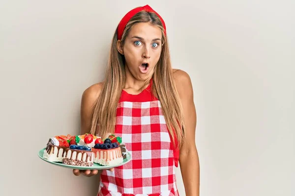 Mladá Blondýna Žena Pekařské Uniformě Drží Domácí Dorty Strach Ohromen — Stock fotografie