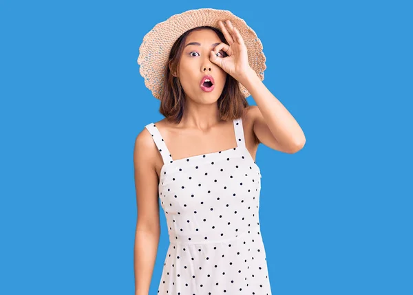 若い美しい中国の女の子の夏の帽子を着用し をジェスチャーを驚きの顔でショックを受けて 目の指を見て 信じられない表現 — ストック写真