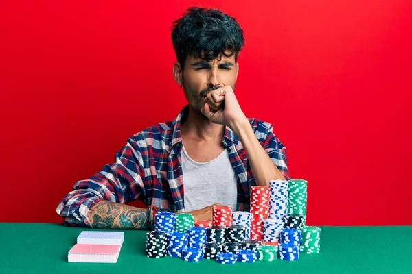 Jovem Hispânico Sentado Mesa Com Fichas Poker Cartas Sentindo Mal — Fotografia de Stock