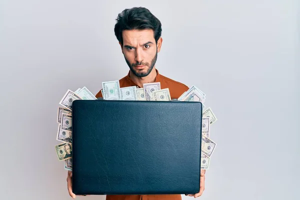 Young Hispanic Man Holding Briefcase Dollars Skeptic Nervous Frowning Upset — Stock Photo, Image