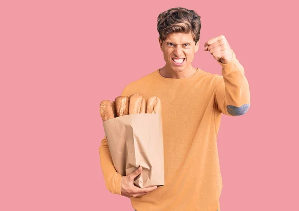 Junger Gutaussehender Mann Mit Papiertüte Und Brot Genervt Und Frustriert — Stockfoto