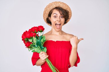 Şapkalı, çiçekli genç bir kadın başparmağını kaldırmış, ağzı açık gülümsüyor. 