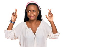 Sıradan kıyafetler giyen genç siyah kadın umut ve gözlerin kapalı gülümseyerek el sallıyor. Şans ve batıl inançlar. 