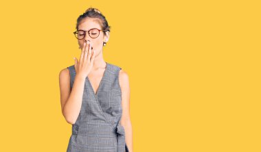 Sarı saçlı, iş kıyafetleri ve gözlükler takan, esnemekten sıkılmış, ağzı eliyle kapatan güzel beyaz bir kadın. Huzursuz ve uykulu.. 