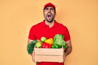 Yakışıklı, sakallı, üniformalı, elinde yiyecek, kızgın ve kızgın çığlıklar atan sinirli, öfkeyle bağıran bir adam.. 