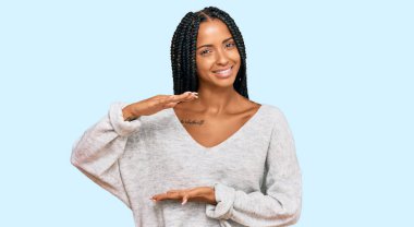 Güzel İspanyol kadın, sıradan kıyafetler giyiyor. Elleriyle işaret ediyor. Büyük ve büyük beden işareti, ölçü sembolü. Kameraya bakıp gülümsüyor. ölçüm kavramı. 