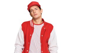 Beyzbol üniforması giyen yakışıklı beyaz adam yüzünde ciddi bir ifadeyle rahatlamış. Basit ve doğal bir şekilde kameraya bakıyorsun.. 