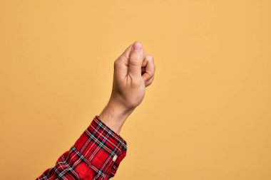İzole edilmiş sarı arka planda parmaklarını gösteren beyaz bir adamın eli. Parmak, iş ve reklamla boş bir alan tutuyor.