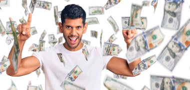 Gündelik kıyafetler giymiş, çılgın bir ifadeyle bağıran genç latin adam elleri havada rock sembolü yapıyor. Müzik yıldızı. ağır müzik konsepti.