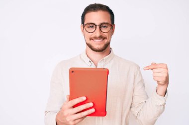 Genç yakışıklı adam dokunmatik bir cihaz kullanıyor. Gülümseyen mutlu ve gururlu birini işaret ediyor. 