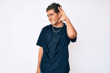 Gündelik kıyafetler giyen genç yakışıklı adam kulağı kulağında gülümseyen ve dedikoduları ya da dedikoduları dinleyen. Sağırlık kavramı. 