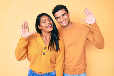 Güzel, Latin, genç bir çift, günlük kıyafetlerini giyip selamlaşıyorlar. Mutlu ve gülümsüyorlar. 