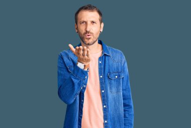 Gündelik kıyafetler giymiş genç yakışıklı bir adam kameraya bakıyor ve havada bir öpücük savuruyor. Güzel ve seksi. aşk ifadesi. 