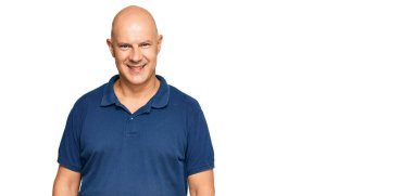 Orta yaşlı kel bir adam mutlu ve havalı bir gülüşü olan sıradan kıyafetler giyiyor. şanslı kişi. 