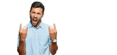 Yakışıklı İspanyol adam gündelik giysiler içinde çılgın bir ifadeyle bağırıyor elleri havada rock sembolü yapıyor. Müzik yıldızı. ağır kavram. 