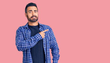 Gündelik kıyafetler giyen genç İspanyol adam endişeli ve gergin bir şekilde işaret ediyor. 