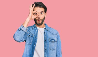 Gündelik kıyafetler giyen genç İspanyol adam şaşırmış yüz ifadesiyle şok olmuş, parmaklarından bakan gözler. İnançsız ifade. 