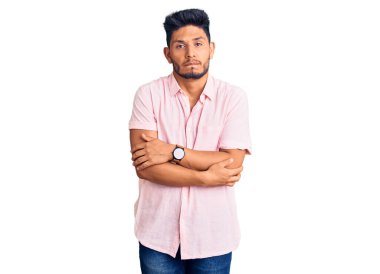 Yakışıklı Latin Amerikalı sıradan bir yaz tişörtü giymiş soğuk algınlığı için titriyor ve donuyor, yüzünde üzgün ve şok ifadesi var. 